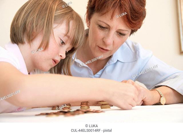 Mother and daughter counting coins