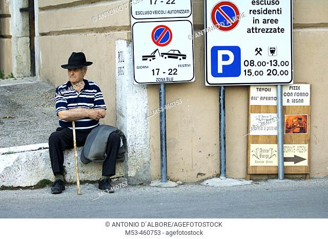 Old men sit on sidewalk, Sant'Agata dei Goti village. Benevento, Campania, Italy