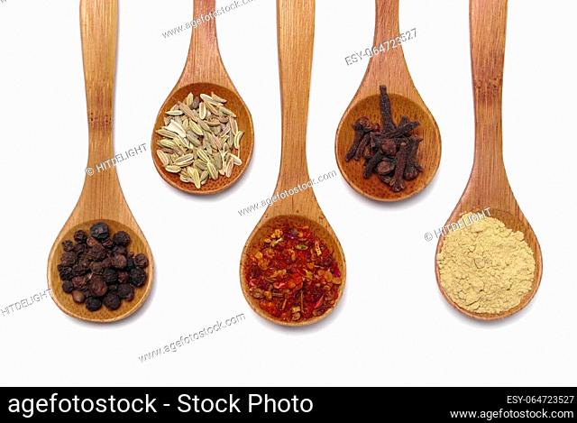 Various of spices in wooden spoon isolated over white
