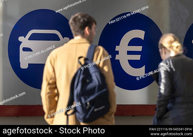 PRODUCTION - 14 November 2022, Berlin: Two stickers with pictograms for car and money are affixed to a window of the branch of Pfando, a car rental company