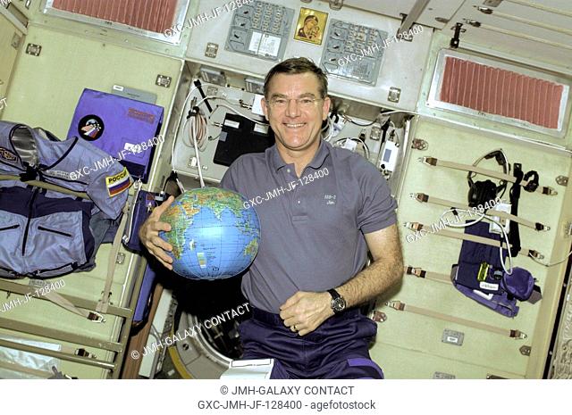 Astronaut James S. Voss, Expedition Two flight engineer, holds a globe to be used for assistance in Earth observation duties