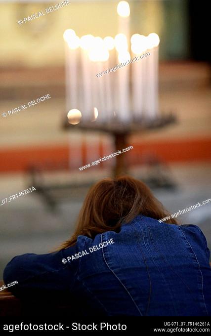 Catholic woman praying in church. France