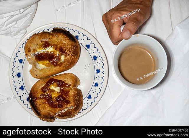 A coouple have toast and coffee in bed