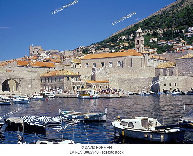 Harbour. View of old buildings. Red tiled roofs. Boats moored