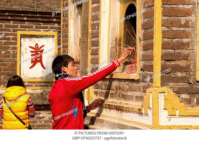 Vietnam: Placing incense sticks at the Tran Quoc Pagoda (Tran Quoc Buddhist temple), Ho Tay (West Lake), Hanoi