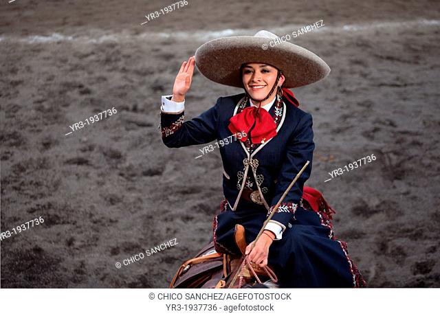 A escaramuza from El Pedregal team salutes as she sits on her horse before competing in an Escaramuza competition in the Lienzo Charros del Pedregal