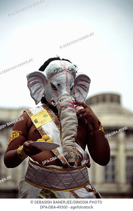 Child performing Lord Ganesh ganpati holding plate of modak