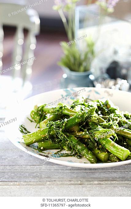 Cooked asparagus with steamed rocket and sesame seeds