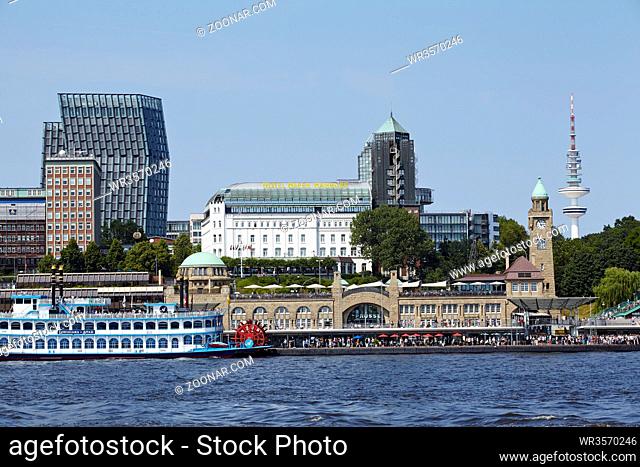 Die Landungsbrücken, das Hotel Hafen Hamburg und die Skyline Hamburgs von Elbufer gegenüber den Landungsbrücken