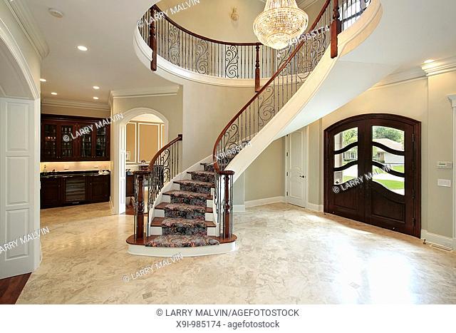 Foyer in new construction home with curved staircase