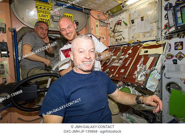 European Space Agency astronaut Alexander Gerst, Expedition 40 flight engineer, shaves the head of NASA astronaut Steve Swanson, commander