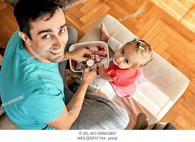 Little girl and her father playing together at home