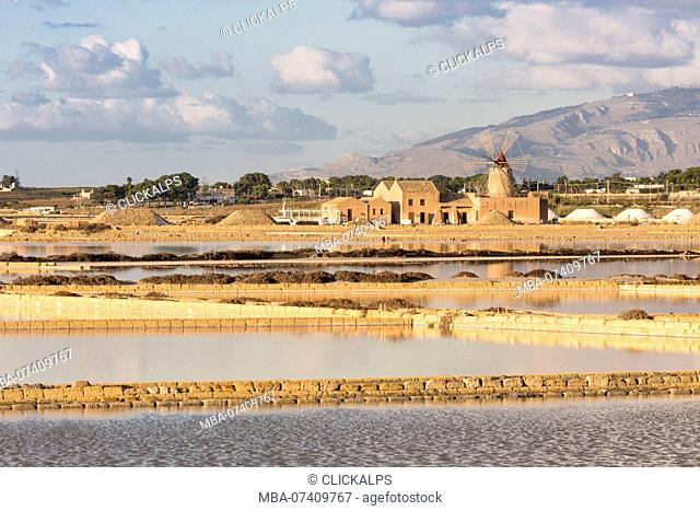 Salt pans in front of Infersa windmill on the coast connecting Marsala to Trapani, Trapani province, Sicily, Italy