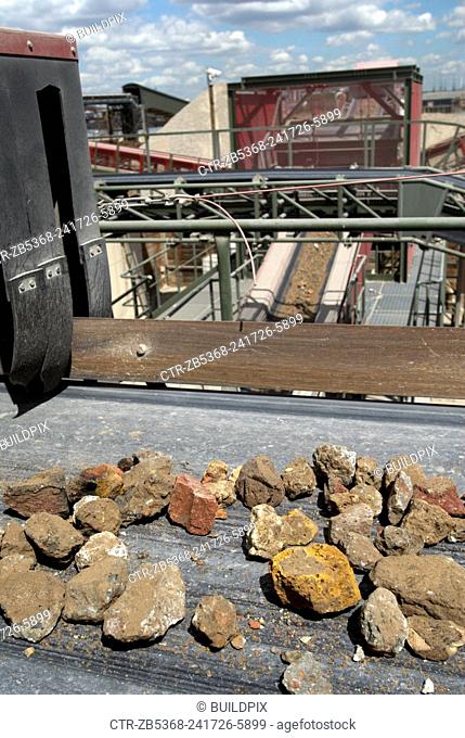Aggregate rubble on a conveyor belt at a construction materials and recycling plant, Greenwich, South-East London, UK