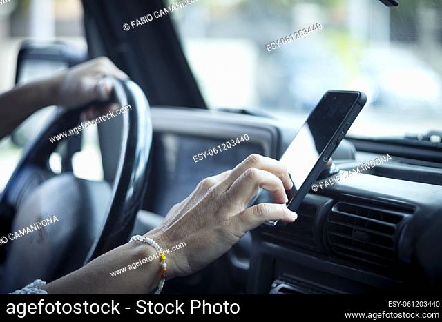 Close up of woman hand setting the gps online navigator on the phone while drive - people and travel with technology help to find the way - using app...