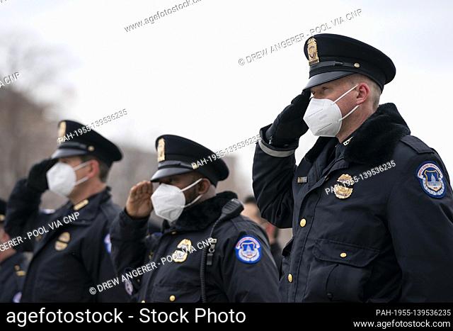 WASHINGTON, DC - FEBRUARY 3: U.S. Capitol Police officers salute as the remains of Officer Brian Sicknick are carried down the steps of the Capitol after laying...