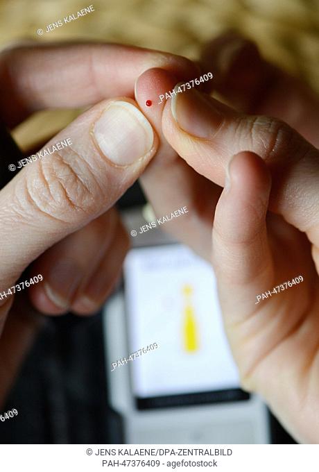 Illustration - A woman, suffering from diabetes, squeezes a drop of blood from her finger after pricking, to monitor the blood sugar levels in her body in...