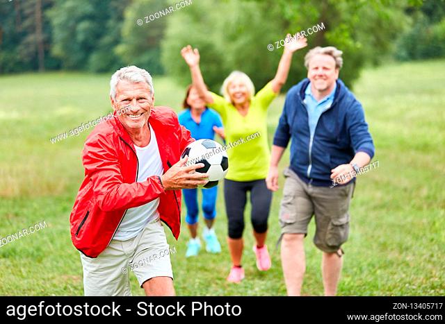 Gruppe Senioren spielt mit einem Fußball bei einem Wettkampf oder Sportfest