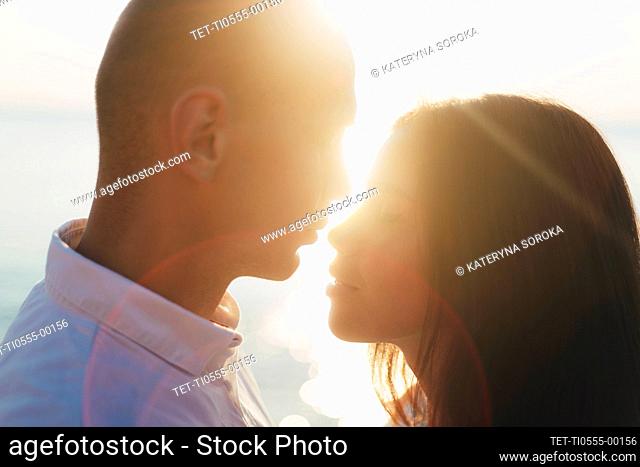 Couple face to face, backlit with sun rays