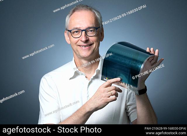 25 June 2021, Saxony, Dresden: Karl Leo, Director of the Institute of Applied Physics (IAP) at TU Dresden, holds a solar module in the Hermann Krone Building