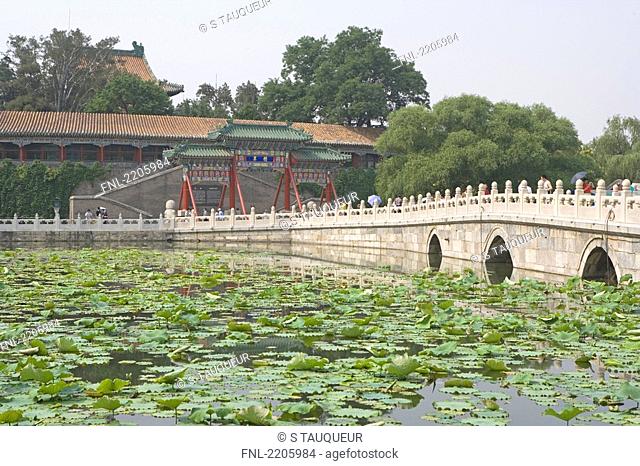 Group of people on bridge across pond, Beihai Park, Beijing, China