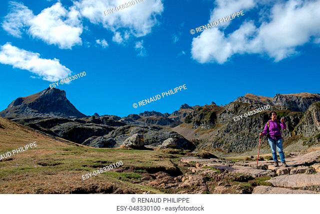 a woman hiker walking in the Pyrenees mountains near the Pic Ossau