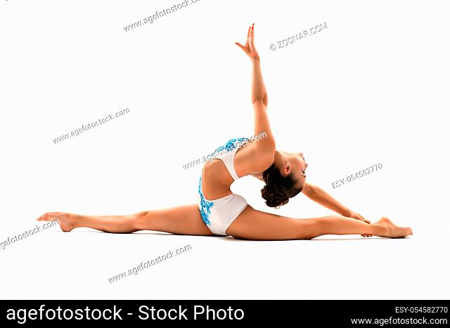 Young female gymnast doing side splits and bending gracefully back view in profile studio shot