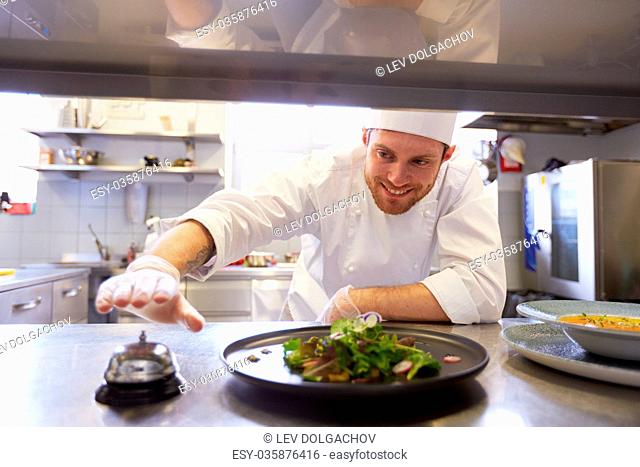 happy male chef cooking food at restaurant kitchen