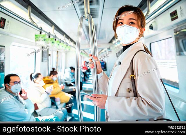 Wearing a mask of the young women take the subway