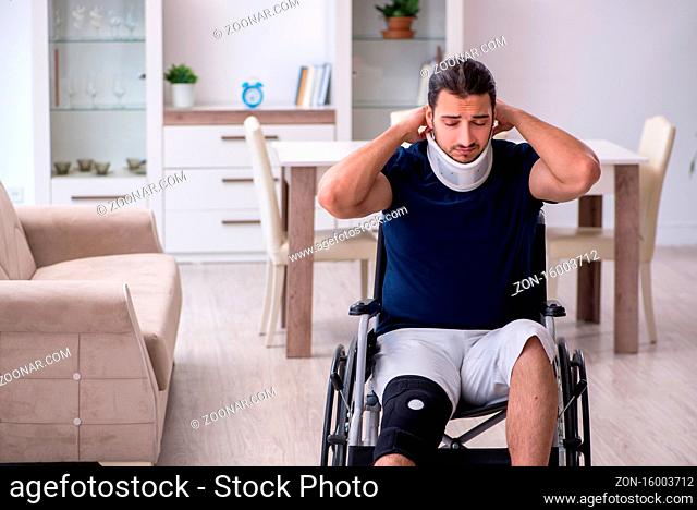 Young leg injured man in wheelchair suffering at home