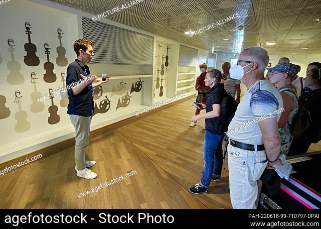 18 June 2022, Hamburg: Alan Schuler (l), project manager, explains a place for storing musical instruments backstage during a guided tour at the Elbphilharmonie...