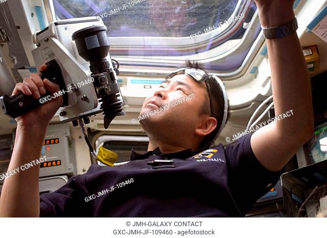 Japan Aerospace Exploration Agency (JAXA) astronaut Akihiko Hoshide, STS-124 mission specialist, uses a handheld laser ranging device on the aft flight deck of...