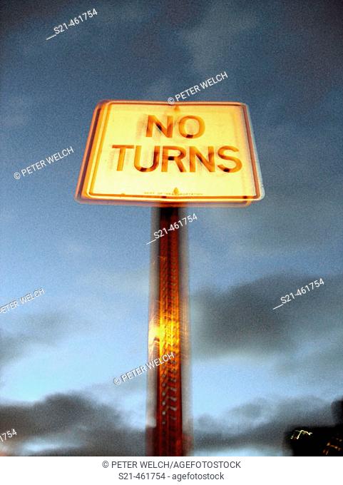 Blurred Street sign 'No Turns' shot against a dusk sky gives a surreal effect that seems to emanate a cosmic energy