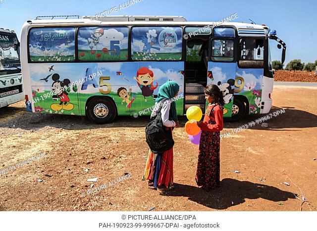 22 September 2019, Syria, Hazano: Syrian children are seen outside a bus which is converted into a classroom. Local teachers have invented the mobile schools to...