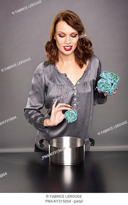 Young woman cooking seaweed pasta
