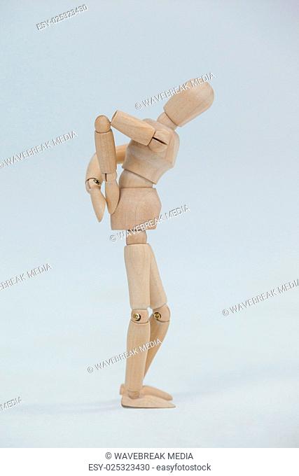 Wooden figurine standing with hands on back