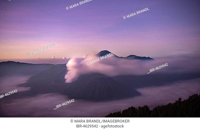 Volcanic landscape at sunrise with starry sky, smoking volcano Gunung Bromo, with Mt. Batok, Mt. Kursi, Mt. Gunung Semeru, National Park Bromo-Tengger-Semeru