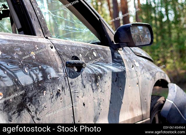 A car of civilians shot by the invaders during the war in Ukraine. Road accident or incident, car accident. Shrapnel holes in the body of the car