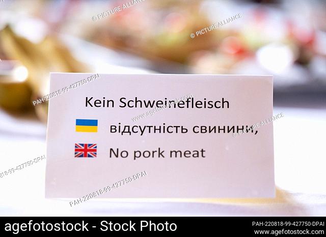 17 August 2022, Saxony, Dresden: A sign reading ""No pork"" is displayed in German, Ukrainian and English at a buffet on a table