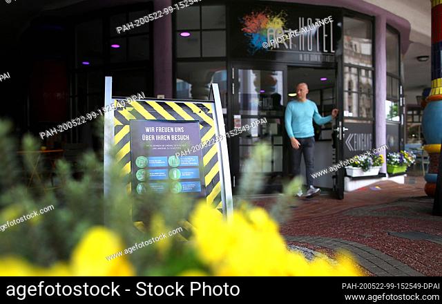22 May 2020, Saxony-Anhalt, Magdeburg: A sign with hygiene instructions is placed in front of the entrance of the Arthotel in the Hundertwasser house 'Grüne...