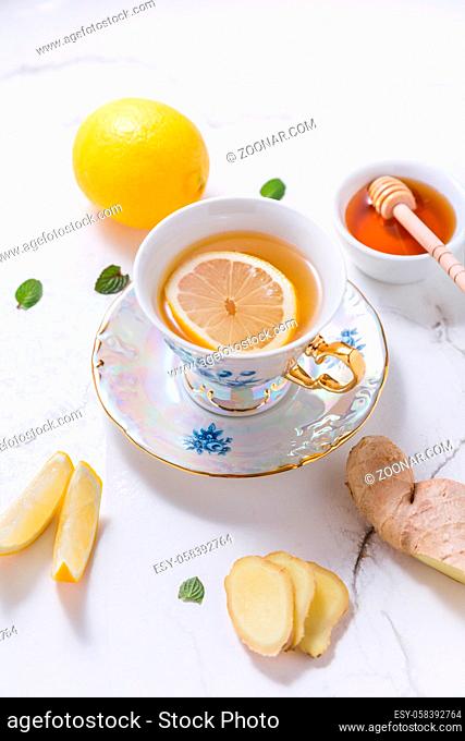 Tea with lemon, ginger and honey as natural medicine on white background