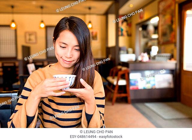 Woman having cup tea in japanese restaurant