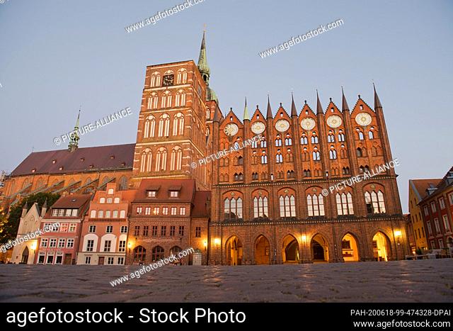 15 June 2020, Mecklenburg-Western Pomerania, Stralsund: View of the St. Nikolai church and the town hall (r) at the ""blue hour""