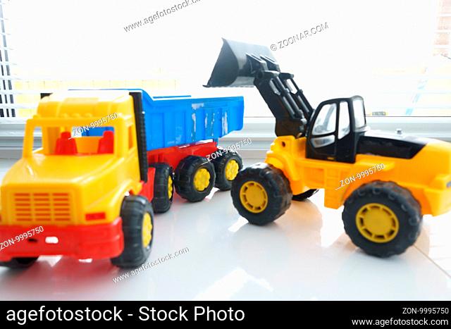 Toy Wheel Loader and Toy Dump Truck Close up, Toy Industrial Vehicle, Plastic Wheel Loader Excavator for Earth Moving Works at Construction Site