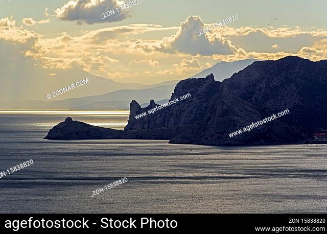 Coastal rocks in the backlight of the evening sun. Crimea, September