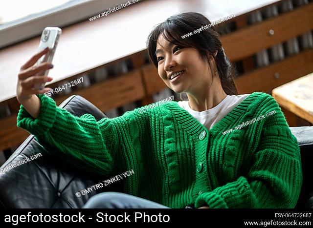 Selfie. Girl in green shirt making selfie on smartphone