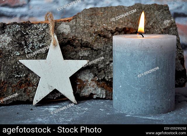 Brennende Kerze, Stern und Holzscheit auf Beton - Burning candle, star and wood billet on concrete
