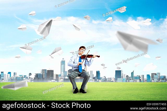 young businessman is engaged in music, concept of creative chaos in business