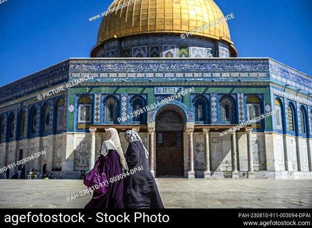 10 August 2023, Israel, Jerusalem: Two Muslim women walk in from of the Dome of the Rock mosque at Al Aqsa compound. Photo: Ilia Yefimovich/dpa