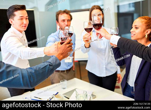 Junge Start-Up Business Leute beim Feiern und Anstoßen mit einem Glas Rotwein